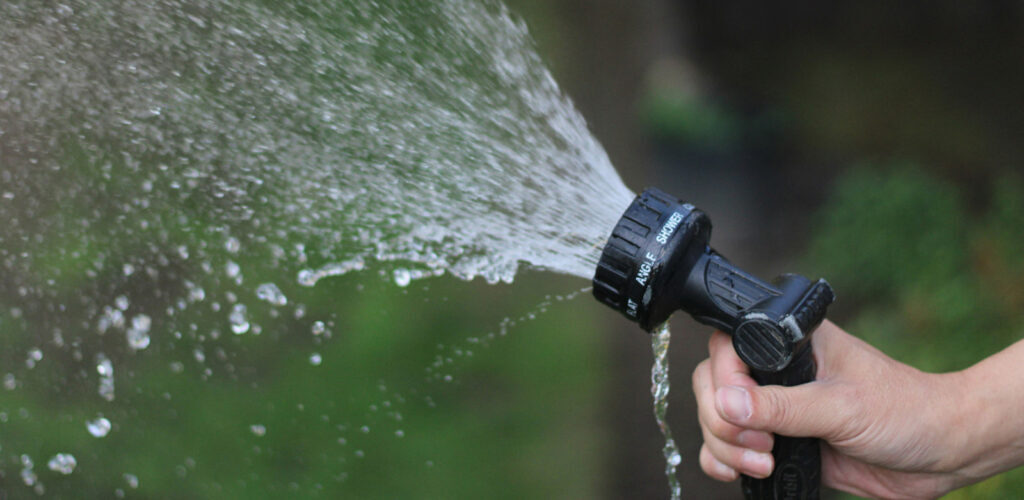 Soft wash hose being sprayed into the air